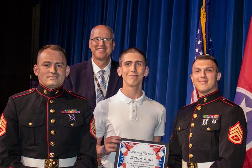 A student is honored for serving in the US Armed Forces after high school